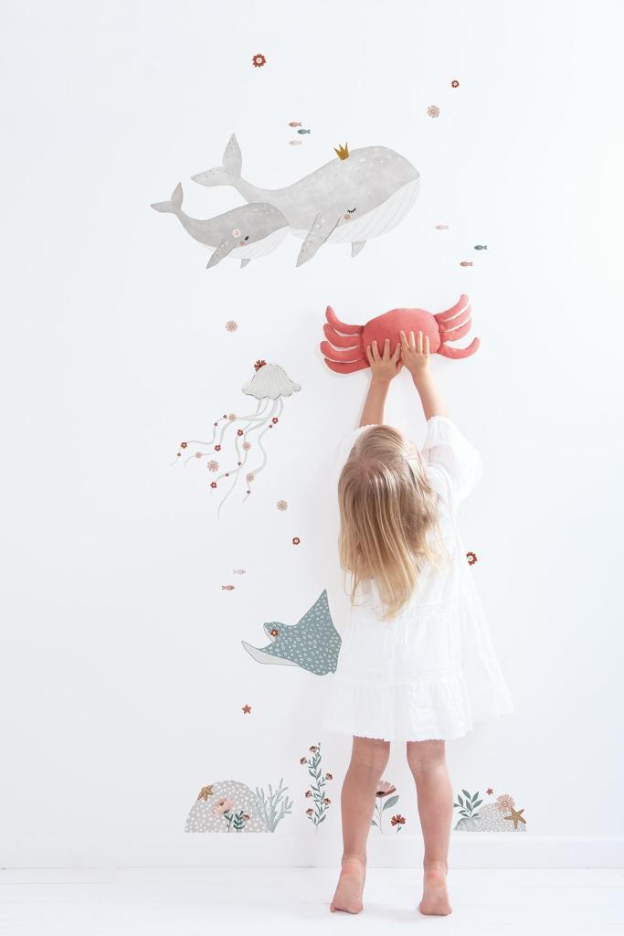 Kind met witte jurk die rood rubberen krabfiguur vasthoudt, voor organische muursticker met grijze walvis, blauwe. - Muursticker | Ocean Field XL - Default Title - kinderkamer, kwal, lilipinso, Muursticker, Oceaan dieren, ocean field, vliesbehang, walvis - Casa Mini