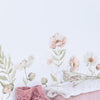 Muursticker met organische zachte roze en beige klaprozen en groene bladeren boven opgevouwen roze en witte babykleding met. - Muursticker | Poppy L/XL - Large - Islandic poppies, kinderkamer, klaproos, lilipinso, Muursticker, vliesbehang - Casa Mini